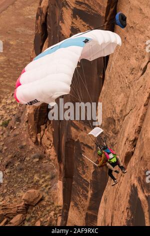 Deux cavaliers de base faisant un 'Mr. Bill' saut en tandem à partir de l'espace Net Mothership 950 pieds au-dessus du plancher de minéral Canyon près de Moab, Utah. Depuis le j Banque D'Images