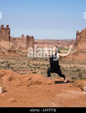 Une jolie jeune femme pratique le yoga à Montagnes La Sal oublier dans Arches National Park près de Moab, Utah. Banque D'Images