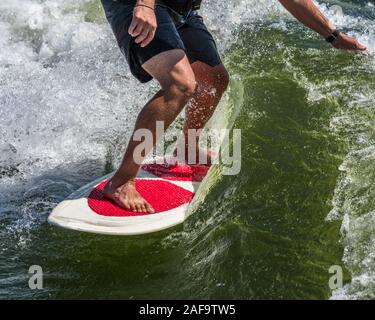 Un jeune homme service surf derrière un bateau sur le Lac Powell, dans le Glen Canyon National Recreation Area dans le sud de l'Utah, USA. Banque D'Images