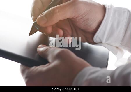 Signer un document numérique thème. Maintenez l'homme stylo tactile sur tablet Banque D'Images