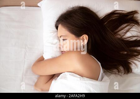 Vue de dessus de calme girl relaxing in bed sous couverture Banque D'Images