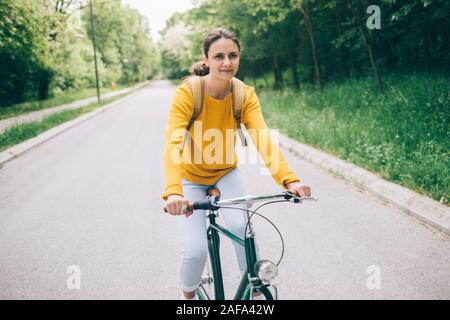 Young woman riding bicycle in the park Banque D'Images