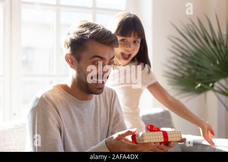 Heureux père surpris par peu d'adorable fille cadeau inattendu Banque D'Images