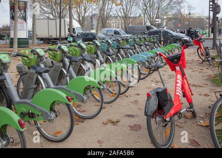 Une station de vélo Vélib à Paris. Le livre vert des vélos de la pédale sont communs à travers Paris et le saut (vélos électrique rouge dirigé par Uber) sont plus récents Banque D'Images