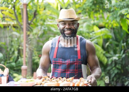 L'Afrique Portrait man toasting et grill barbecue et barbecue prêt à servir Banque D'Images