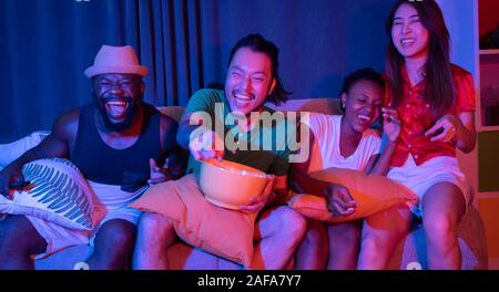 Groupe d'amis s'amusant à la maison regarder le soccer et les films à la télévision. apprécier et célébrer ensemble Banque D'Images