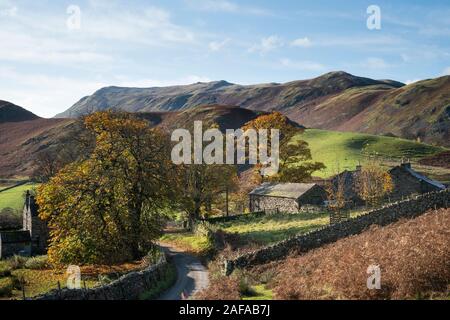 Vieux bâtiments agricoles abandonnés en automne automne image paysage dans la région de Lake District avec grésil tomba en arrière-plan avec la lumière sur l'épique fells Banque D'Images