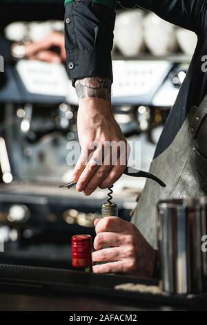 L'ouverture d'une bouteille de vin avec tire-bouchon dans un bar Banque D'Images