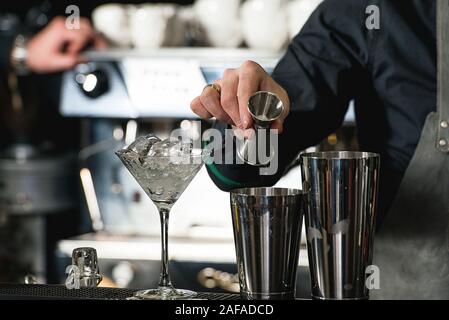 Faire barman cocktail reposant sur un arrière-plan de la barre Banque D'Images