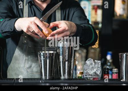 Faire barman cocktail reposant sur un arrière-plan de la barre Banque D'Images