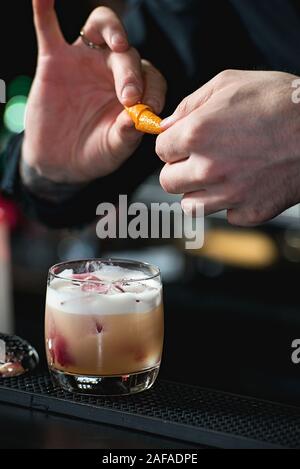 Faire barman cocktail reposant sur un arrière-plan de la barre Banque D'Images