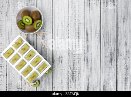 Sucettes de kiwi sur une vieille table en bois (selective focus) Banque D'Images