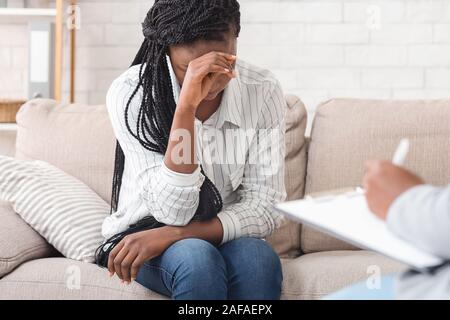 Femme noir désespéré assis sur une consultation personnelle au bureau du psychologue Banque D'Images