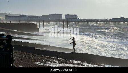 Brighton UK 14 décembre 2019 - Un walker bénéficie de la force de coup de vent par une belle journée ensoleillée le long de la plage de Brighton. Crédit : Simon Dack / Alamy Live News Banque D'Images