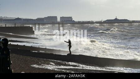 Brighton UK 14 décembre 2019 - Un walker bénéficie de la force de coup de vent par une belle journée ensoleillée le long de la plage de Brighton. Crédit : Simon Dack / Alamy Live News Banque D'Images