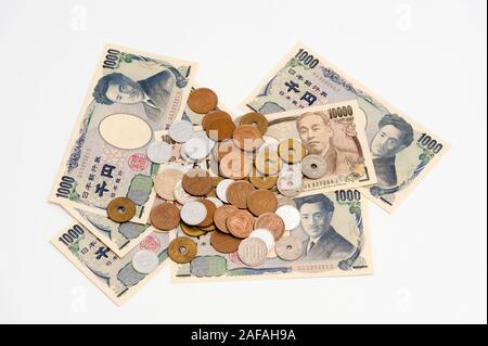 Yen japonais - l'argent dans l'un mille yens, dix mille yens billets et pièces diverses isolé sur fond blanc avec l'exemplaire de l'espace. Plan horizontal. Banque D'Images