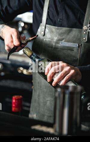 L'ouverture d'une bouteille de vin avec tire-bouchon dans un bar Banque D'Images