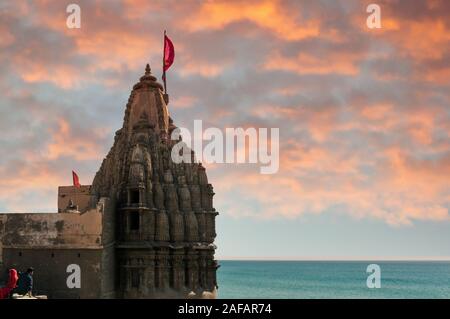 Temple Hindou avec murs sculptés un spire et drapeau sur la côte de la mer bleue Banque D'Images