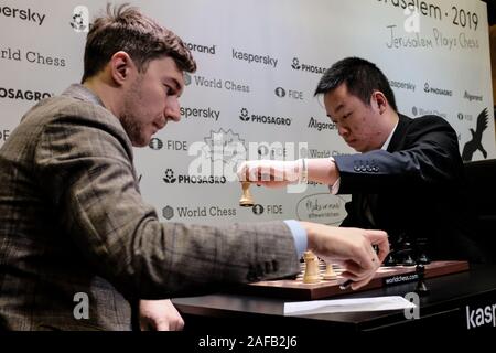 Jérusalem, Israël. 14 Décembre, 2019. SERGEY KARJAKIN (L), 29 ans, de la Russie en compétition avec WEI YI (R), 20 ans, de la Chine, lors de la ronde 2, Jeu 1, de la dernière étape de la World Chess Championship au cycle du Centre Notre Dame de Jérusalem. Huit concurrents restent des 16 meilleurs grands maîtres qui ont commencé le tournoi dans leur lutte pour un prix de 800 000 euros, deux places dans le prochain tournoi des candidats et une chance d'affronter le Champion du Monde, Magnus Carlsen, dans le match de championnat 2020. Le tournoi a un format knock out avec 16 joueurs au départ. Pour gagner, un joueur doit vaincre oppon Banque D'Images