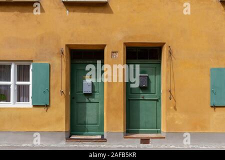 Des portes basses typiques dans le quartier Fuggerei, une enclave fortifiée au sein de la ville d'Augsbourg, Bavière, Allemagne. Banque D'Images