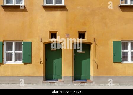 Des portes basses typiques dans le quartier Fuggerei, une enclave fortifiée au sein de la ville d'Augsbourg, Bavière, Allemagne. Banque D'Images