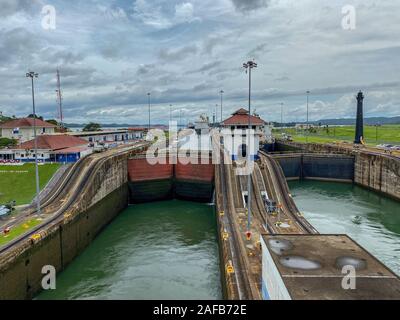 Panama - 11/6/19 : vue d'un porte-conteneurs et deux yachts entrant dans la première écluse du canal de Panama à partir d'un bateau de croisière beaucoup plus bas. Banque D'Images