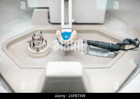 Mâchoire artificielle pour la modélisation des implants avec jeu de fraises dentaires sur le lieu de travail de technicien en laboratoire dentaire Banque D'Images