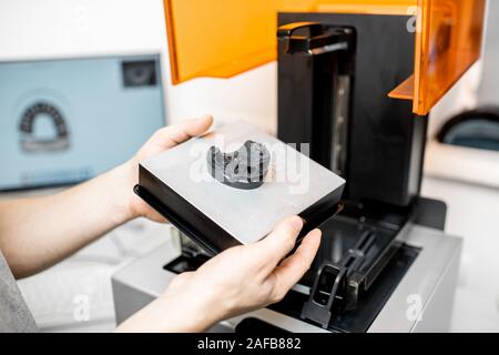 Technicien dentaire retrait jaw modèle à partir d'un imprimante 3D au laboratoire, la modélisation pour la production d'implant Banque D'Images