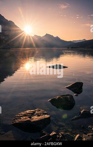Lever du soleil sur la montagne rocheuse avec des pierres dans le lac Medicine à Jasper National Park, Canada Banque D'Images