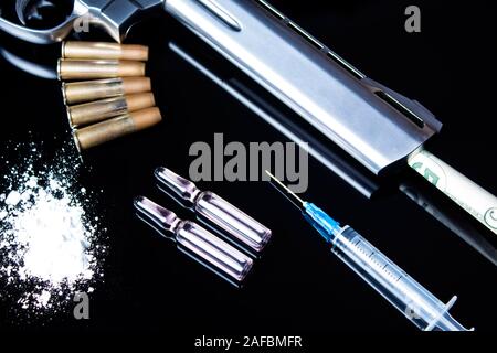 Un pistolet à balles, seringue et les médicaments se trouvent sur le tableau noir. Mauvaises habitudes dangereuses, la dépendance aux drogues et du jeu. Crime à cause de la drogue. La vente, Banque D'Images