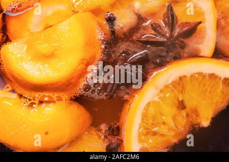 La préparation de boissons vin chaud avec des oranges et des épices. Les boissons de Noël faire bouillir dans le moule en métal. Glintwine de vin rose avec des agrumes, de girofle Banque D'Images