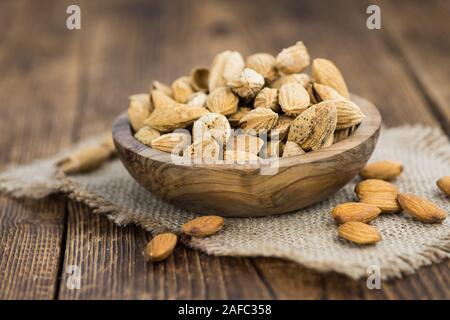 Amandes rôties (en shell) sur une vieille table en bois (close-up shot, selective focus) Banque D'Images