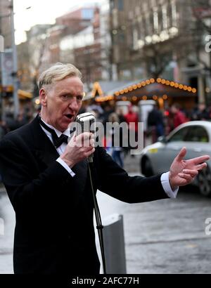 Manchester, UK. 14 Décembre, 2019. Un chanteur entretient avec certains acheteurs classiques de Noël à l'approche de Noël à Manchester, Lancashire, Royaume-Uni. Crédit : Barbara Cook/Alamy Live News Banque D'Images