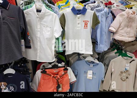 Vêtements pour enfants dans un magasin de près. Des chemises et blouses d'enfants sur les épaules dans le magasin d'articles pour enfants. Banque D'Images