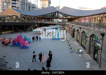 Personnes visitant les boutiques du centre commercial Coal Drops Yard à l'heure de Noël dans la région de Kings Cross de N1 Londres Angleterre Royaume-Uni KATHY DEWITT Banque D'Images