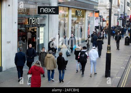 Foule de gens passant devant les acheteurs entrée de nouveau magasin shopping sur Oxford Street en hiver Décembre Londres Angleterre Royaume-uni KATHY DEWITT Banque D'Images