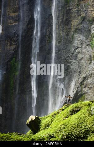 Superbe vue d'un touriste à bras ouverts en profitant de la vue de la Sewu Tumpak Cascades. Banque D'Images