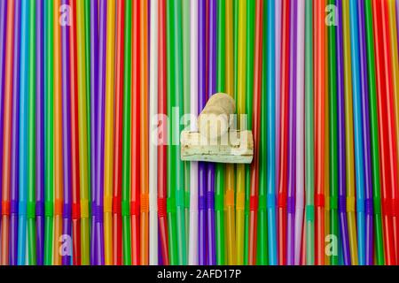 Pailles à boire. Résumé fond avec beaucoup de plastique multicolores ou un cocktail de jus de tubules, jetables à usage unique. Et deux capsules de bouteille dans le Banque D'Images