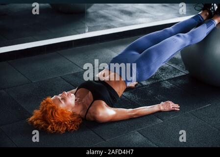 À l'aide de balles de couleur argent. Jeune fille rousse Sport fitness salle de sport dans la journée sont à jour. Type de corps musculaire Banque D'Images