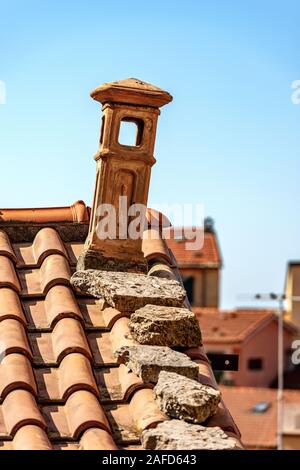 Libre d'une maison avec un toit de tuiles en terre cuite et cheminée sur un ciel bleu clair. Ligurie, Italie, Europe Banque D'Images