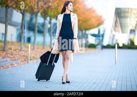 Valise de transport fille par des rues. Smiling blonde smiling Banque D'Images