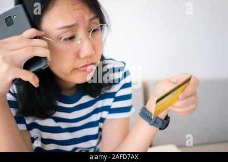 Portrait confus young woman holding credit cards avoir problème en ligne Paiement par carte de crédit faire rejeté unsecure. carte de crédit Paiement en ligne Banque D'Images