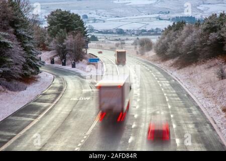 Tebay, Cumbria, Royaume-Uni. 15 Décembre, 2019. Tôt le matin, le gel et les averses de neige couvrant la Tebay paysage d'hiver comme chefs de trafic d'un Shap célèbre spot de conduite difficile à froid dans les Fells Westmorland. Credit : MediaWorldImages/Alamy Live News Banque D'Images