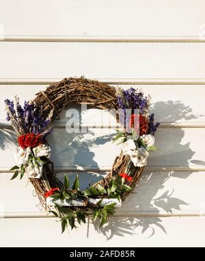 Couronne de Noël de l'imprimante avec la Gazette de Virginie à fond et des roses blanches repliés depuis les pages imprimées. Couronne de paille, Colonial Williamsburg. Banque D'Images