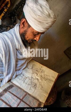 L'Éthiopie, du Tigré, Yeha, Adwa, ancien prêtre affichage manuscrit lumineux avec le dessin monochrome des prêtres avec des bâtons de prière Banque D'Images