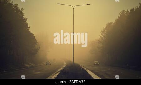 Voitures dans le brouillard. Mauvais temps hivernal et dangereuse de la circulation automobile sur la route. Véhicules dans le brouillard. Banque D'Images