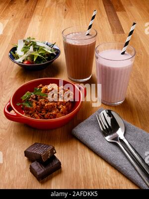 Plan de repas quotidien contrôlé en calories, y compris le petit-déjeuner, un snack-milkshake et repas du soir, tourné sur un fond de bois Banque D'Images