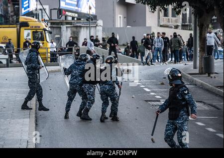 Beyrouth, Liban. 14 Décembre, 2019. Le personnel des forces de sécurité face à face avec des gens qui protestent contre une révolte contre le gouvernement libanais sur la 59e journée de protestation. Du quartier chiite de Bachoura, près du centre-ville de Beyrouth, des contre-manifestants ont attaqué la police et le personnel de l'armée avec des pierres et des feux d'artifice le samedi soir. La police a répondu par des gaz lacrymogènes lors d'une bataille de plusieurs heures. Credit : Elizabeth Fitt/Alamy Live News Banque D'Images