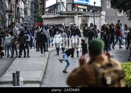 Beyrouth, Liban. 14 Décembre, 2019. Le personnel de l'armée face à face avec les gens qui protestent contre une révolte contre le gouvernement libanais sur la 59e journée de protestation. Du quartier chiite de Bachoura, près du centre-ville de Beyrouth, des contre-manifestants ont attaqué la police et le personnel de l'armée avec des pierres et des feux d'artifice le samedi soir. La police a répondu par des gaz lacrymogènes lors d'une bataille de plusieurs heures. Credit : Elizabeth Fitt/Alamy Live News Banque D'Images