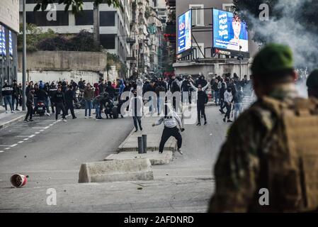 Beyrouth, Liban. 14 Décembre, 2019. Le personnel de l'armée face à face avec les gens qui protestent contre une révolte contre le gouvernement libanais sur la 59e journée de protestation. Du quartier chiite de Bachoura, près du centre-ville de Beyrouth, des contre-manifestants ont attaqué la police et le personnel de l'armée avec des pierres et des feux d'artifice le samedi soir. La police a répondu par des gaz lacrymogènes lors d'une bataille de plusieurs heures. Credit : Elizabeth Fitt/Alamy Live News Banque D'Images